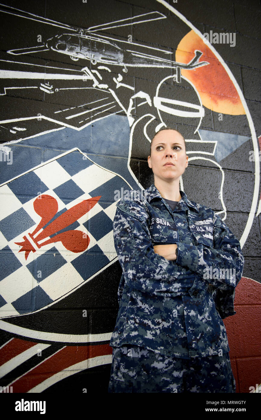 170708-n-CF658-001-19 CORONADO,California (luglio 8th, 2017) -- Aviation da elettricista, Mate 2a classe Marianne DeSilva, assegnato al mare in elicottero Combat Squadron 4 (HSC-4),si erge di fronte i suoi squadroni logo che viene usato per simboleggiare il cavalieri neri. HSC-4 assits principalmente nelle operazioni di ricerca e salvataggio e carico missioni come una parte di Carl Vinson Strike gruppo.(STATI UNITI Navy foto di MC2 Amanda A. Hayes/rilasciato) Foto Stock