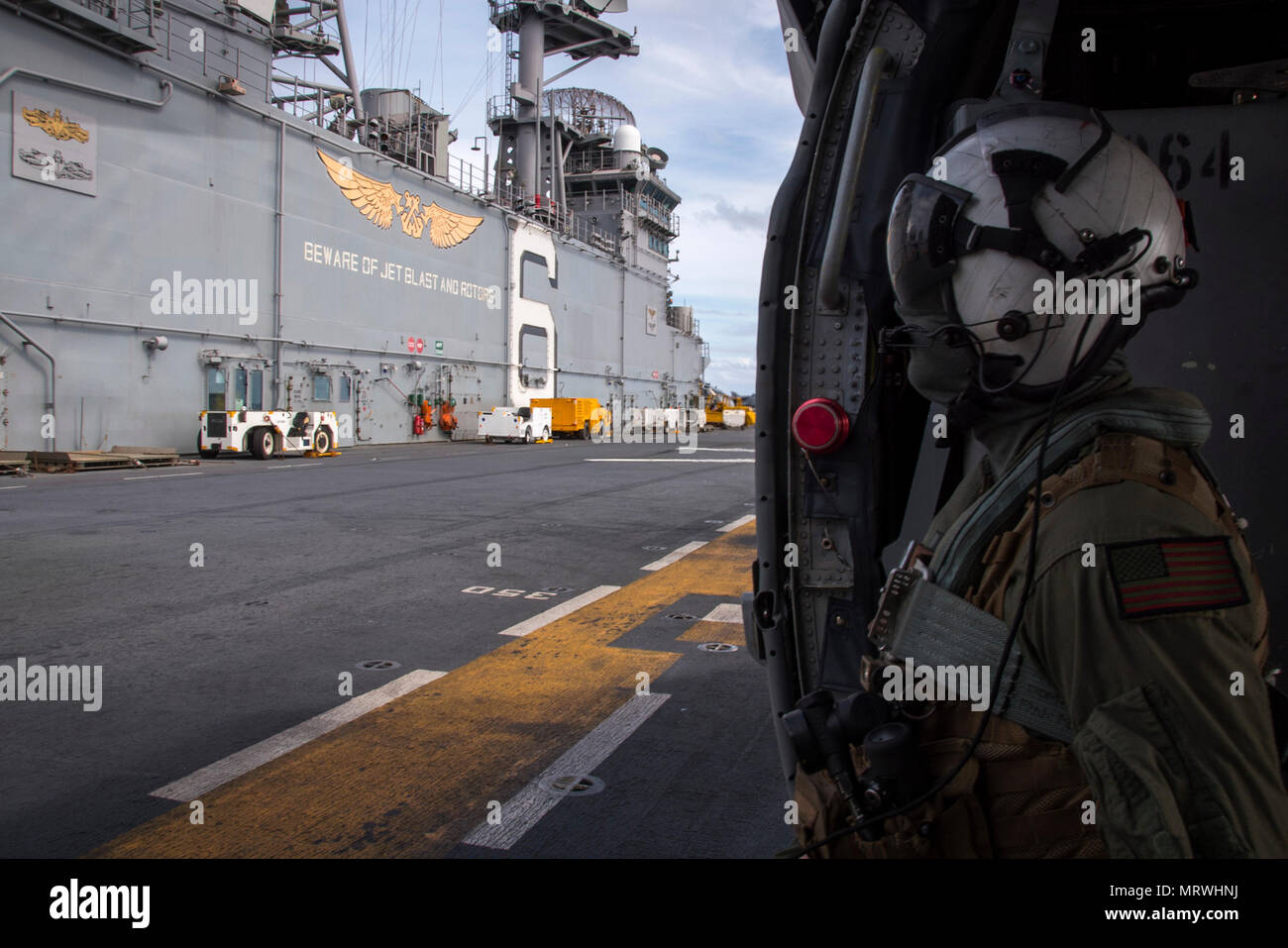 Stati Uniti Navale della Marina Militare Aircrewman (elicottero) terza classe Jacob Ward, da Boston, assegnato al mare in elicottero Combat Squadron (HSC) 25, comunica con i marinai sul ponte di volo dell'assalto anfibio nave USS Bonhomme Richard (LHD 6) nel Mare di corallo Luglio 9, 2017, durante il talismano di Saber 17. Il Bonhomme Richard, parte di un combinato di U.S.-Australia e Nuova Zelanda expeditionary strike gruppo, sta subendo una serie di scenari che aumenterà naval abilità nel funzionamento contro blu-acqua minacce del contraddittorio e nella sua missione primaria di lanciare le forze di marino a terra in marine. Talismano Foto Stock