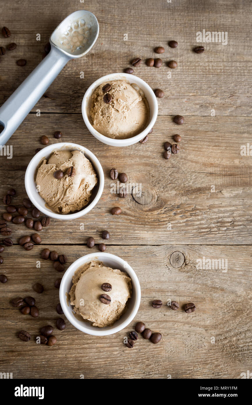 Gelato al caffè su sfondo di legno, vista dall'alto. Congelati Caffè gelato Gelato con i chicchi di caffè e Cannella - sano dessert estivo. Foto Stock