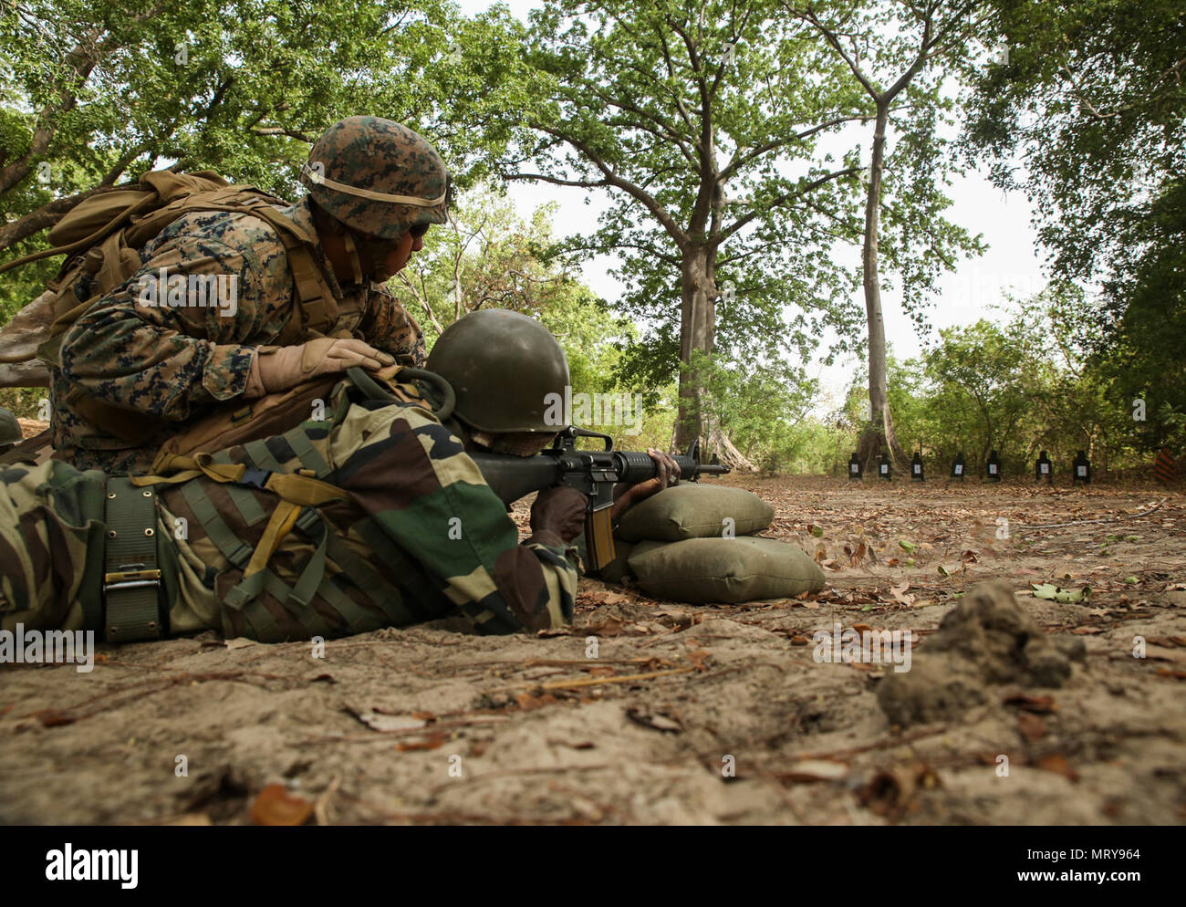 Cpl. Ismael Fonseca, un rifleman con scopi speciali Air-Ground Marine Task Force - Risposta in caso di crisi - Africa, osserva che la precisione di un membro del Senegal di Compagnie Fusilier de Marin Commando durante un live-Incendio campo a Toubakouta, Senegal, 13 aprile 2017. Marines con SPMAGTF-CR-AF e il COFUMACO condotta a quattro alla settimana di formazione professionale esercizio che includeva il combattimento avanzate tecniche di cottura, una mitragliatrice gamma e un live-fire attacco di plotone di gamma. Foto Stock