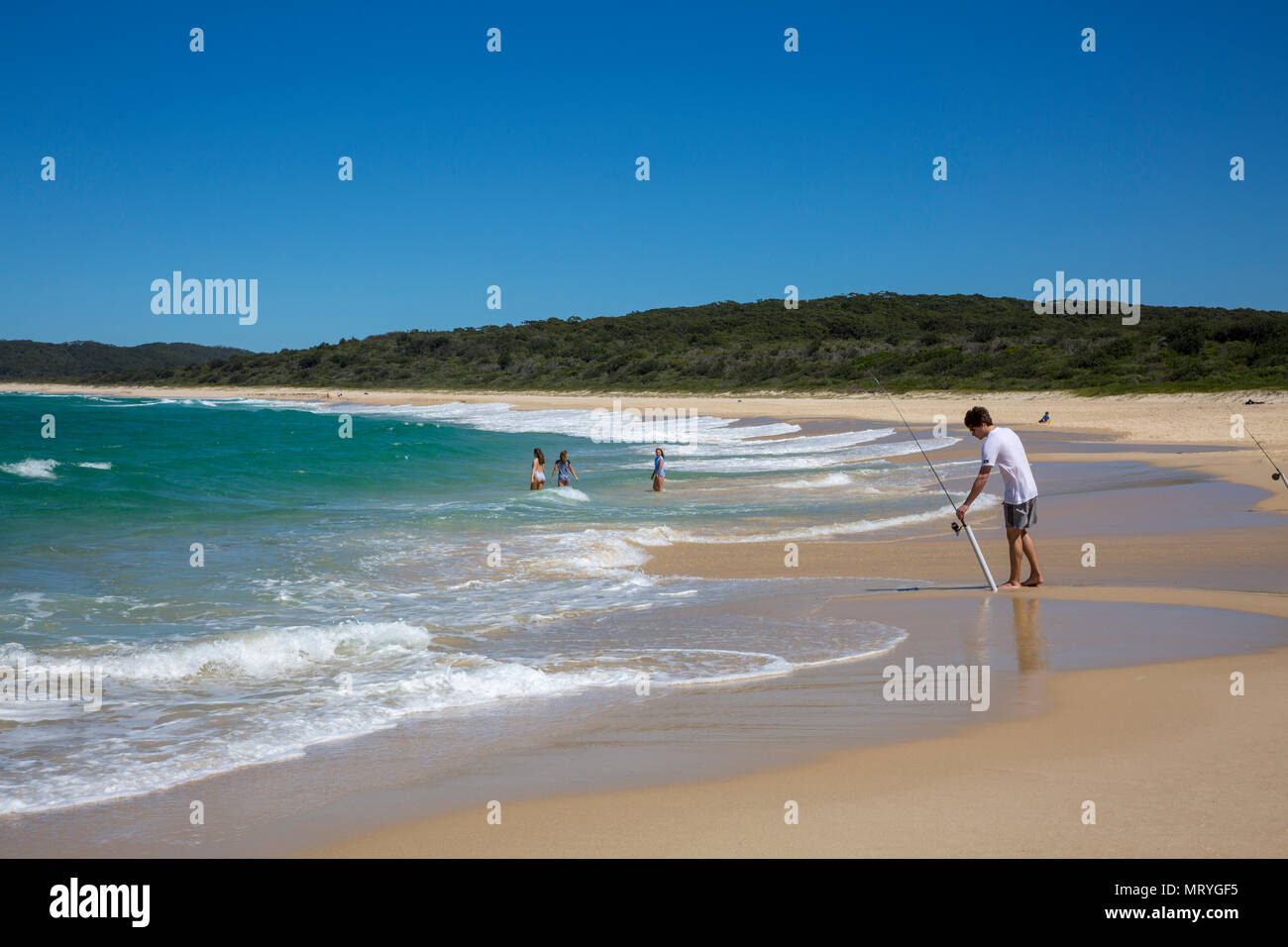 Uomo con attività di pesca nell'oceano a Cellito spiaggia a metà costa nord del Nuovo Galles del Sud, Australia Foto Stock