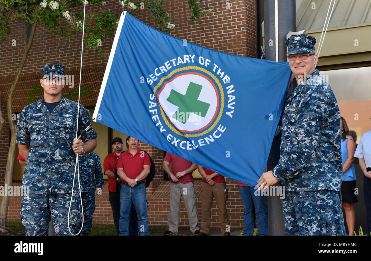170630-N-ZQ220-0001 Kings Bay, Ga. (30 giugno 2017)Capt. Gunter Braun, destra, comandante del Tridente riattaccare Facility Kings Bay, e agendo il comando Master Chief Antonio Vicens pronti per sollevare il segretario della Marina di eccellenza di sicurezza bandiera. Riattaccare Trident Facility è stato recentemente premiato con l'anno fiscale 2016 Sicurezza SECNAV Excellence Award per l'unità di terra della categoria. (U.S. Navy foto di Tim Austin/rilasciato) Foto Stock