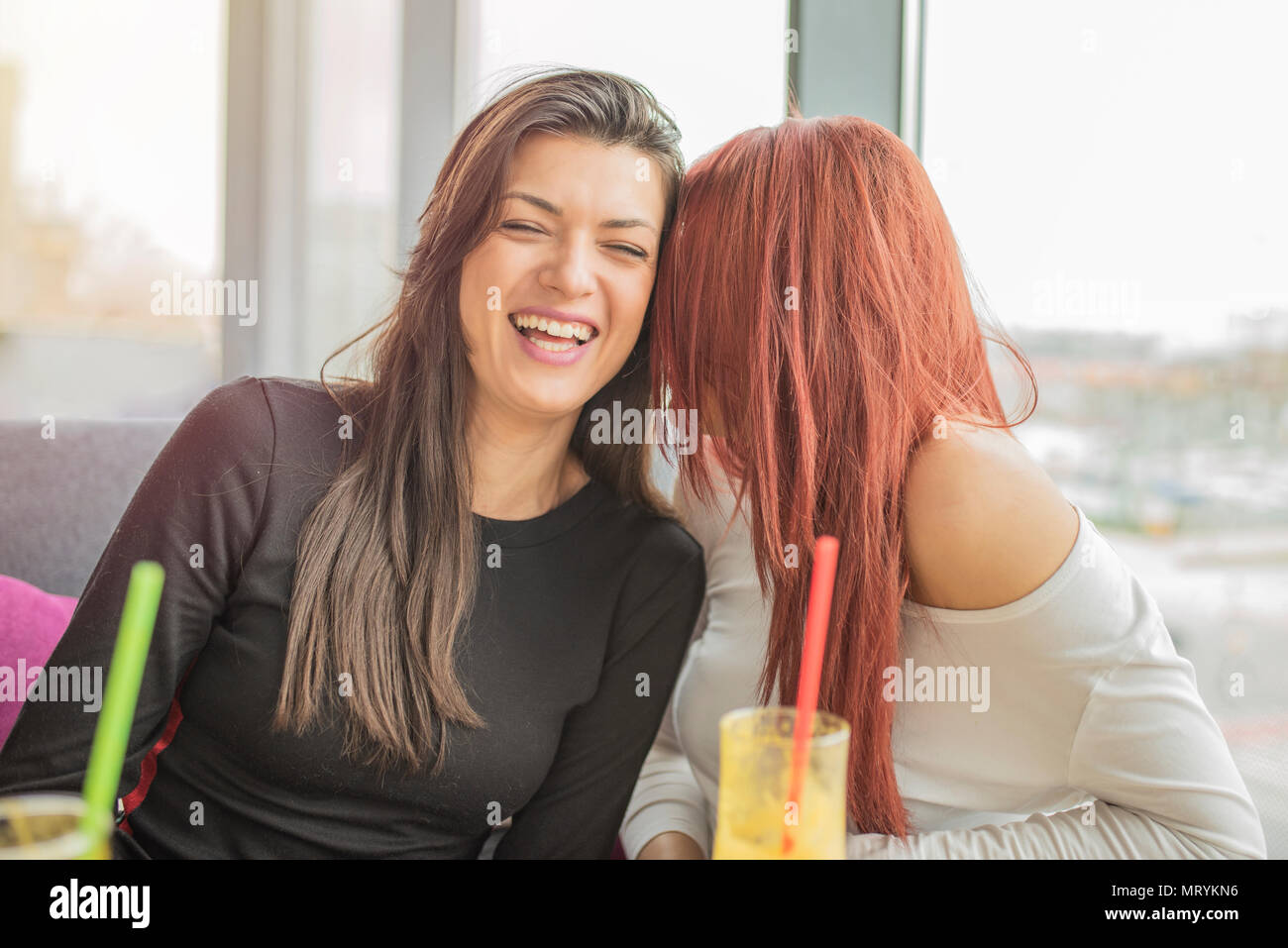 Ritratto di due giovani ragazze belle godendo insieme. Due giovani girl amici divertendosi in un ristorante a ridere, parlare e spettegolare.Le ragazze parlare. Foto Stock