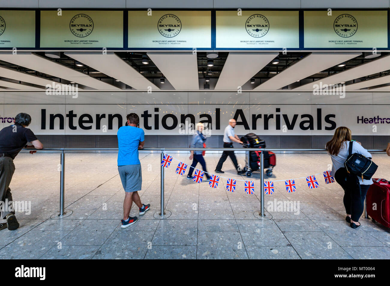 Persone in attesa presso il terminale 5 International Hall Arrivi all'aeroporto di Heathrow di Londra, Regno Unito Foto Stock