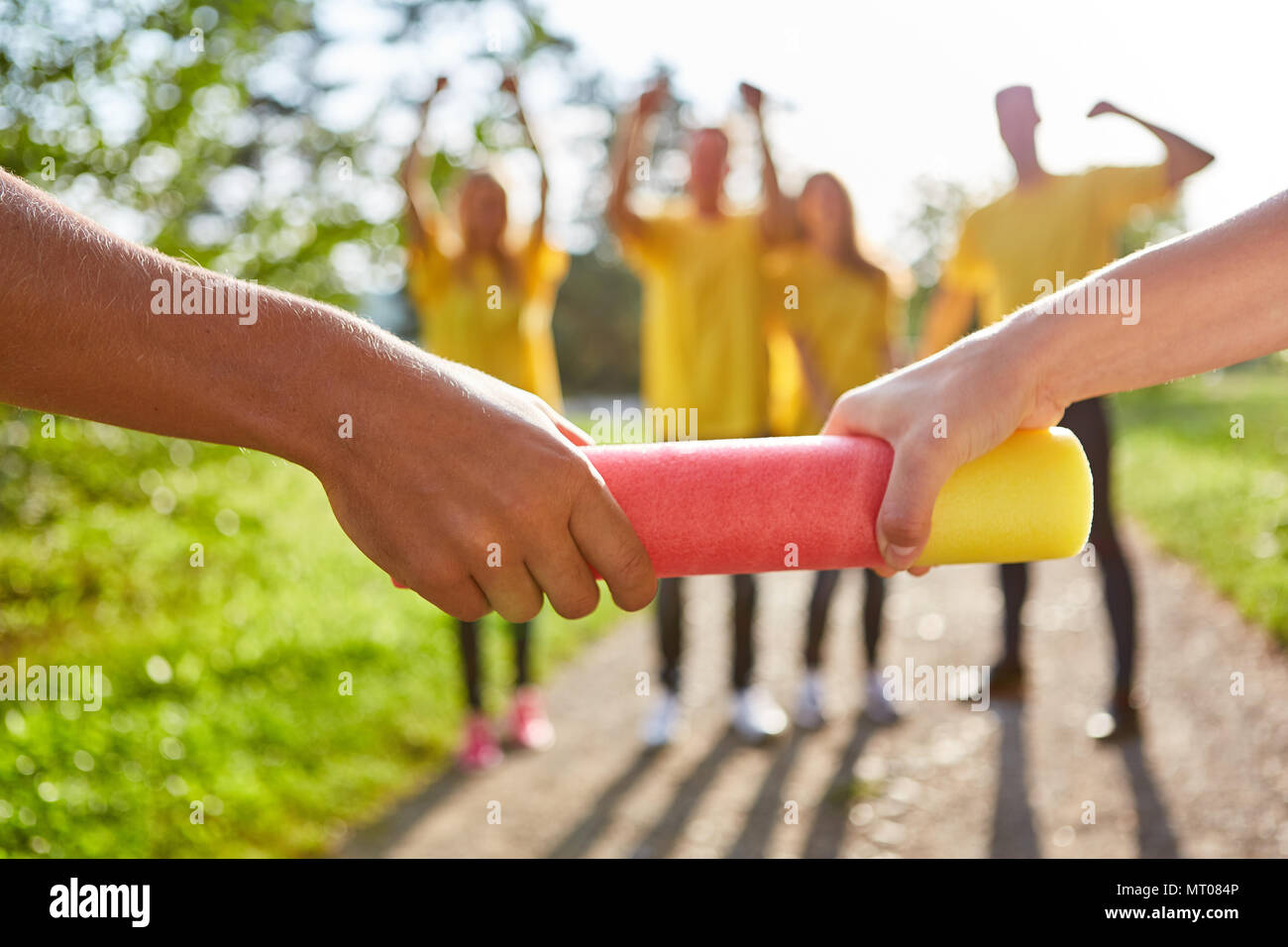 I giovani di consegnare un testimone al teambuilding workshop Foto Stock