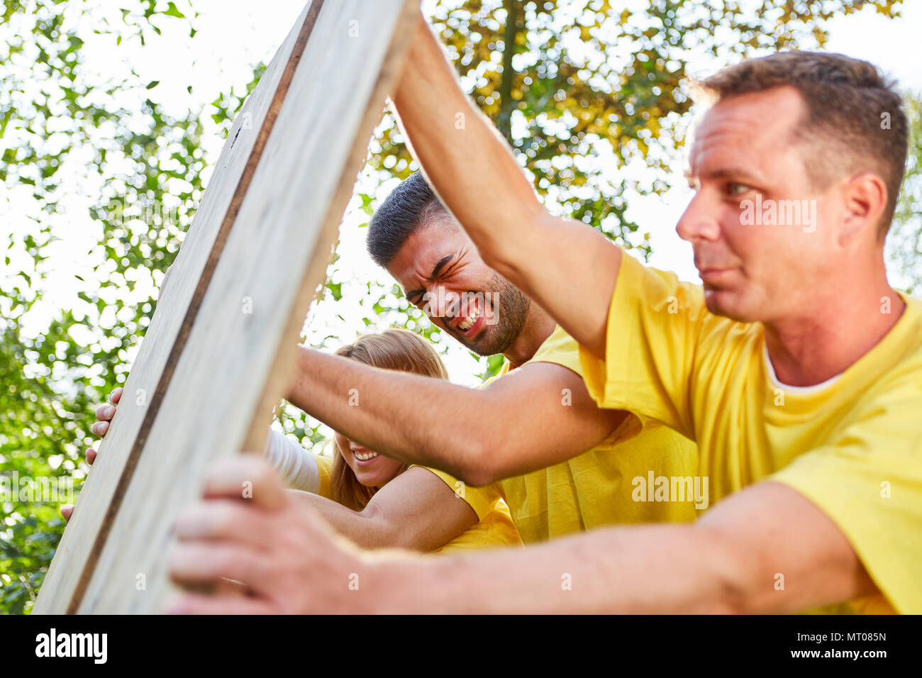 Sporting team sta facendo un esercizio per la forza e il lavoro di squadra al team building event Foto Stock