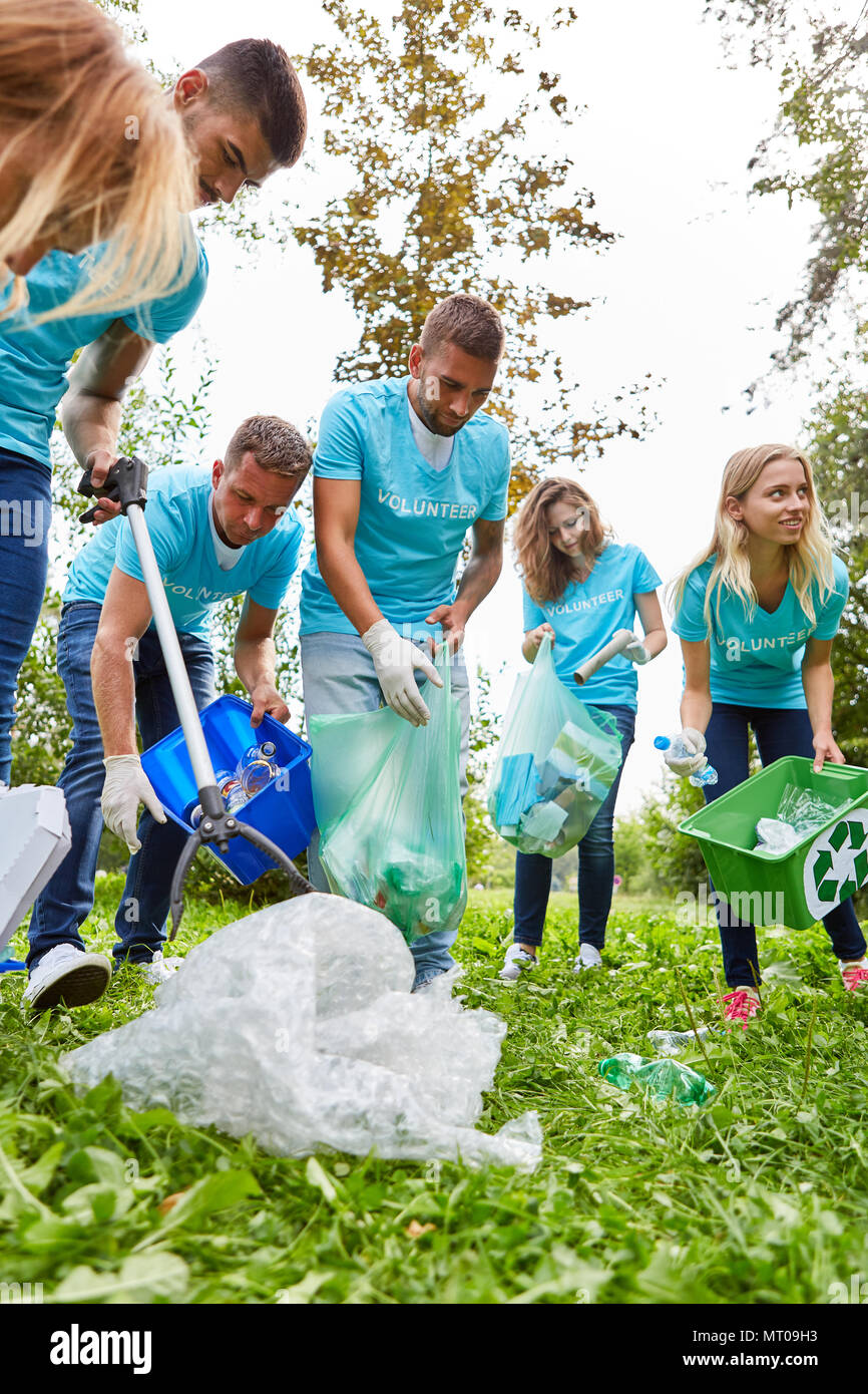 Aiutanti di un gruppo ambientalista raccogliere rifiuti in natura per migliorare il riciclaggio Foto Stock