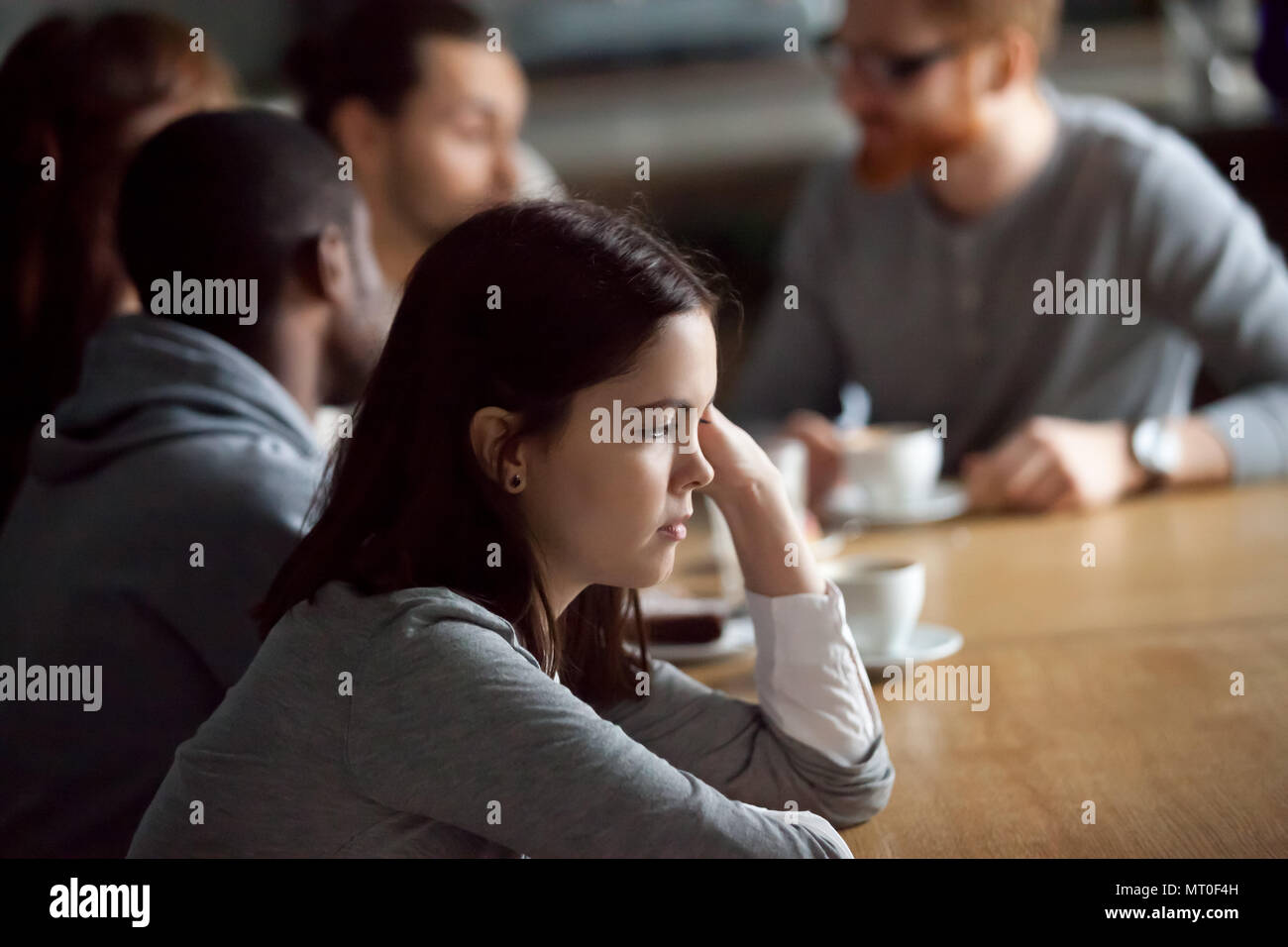 Frustrati sconvolto la millenaria ragazza seduta da sola a tavola in cafe Foto Stock