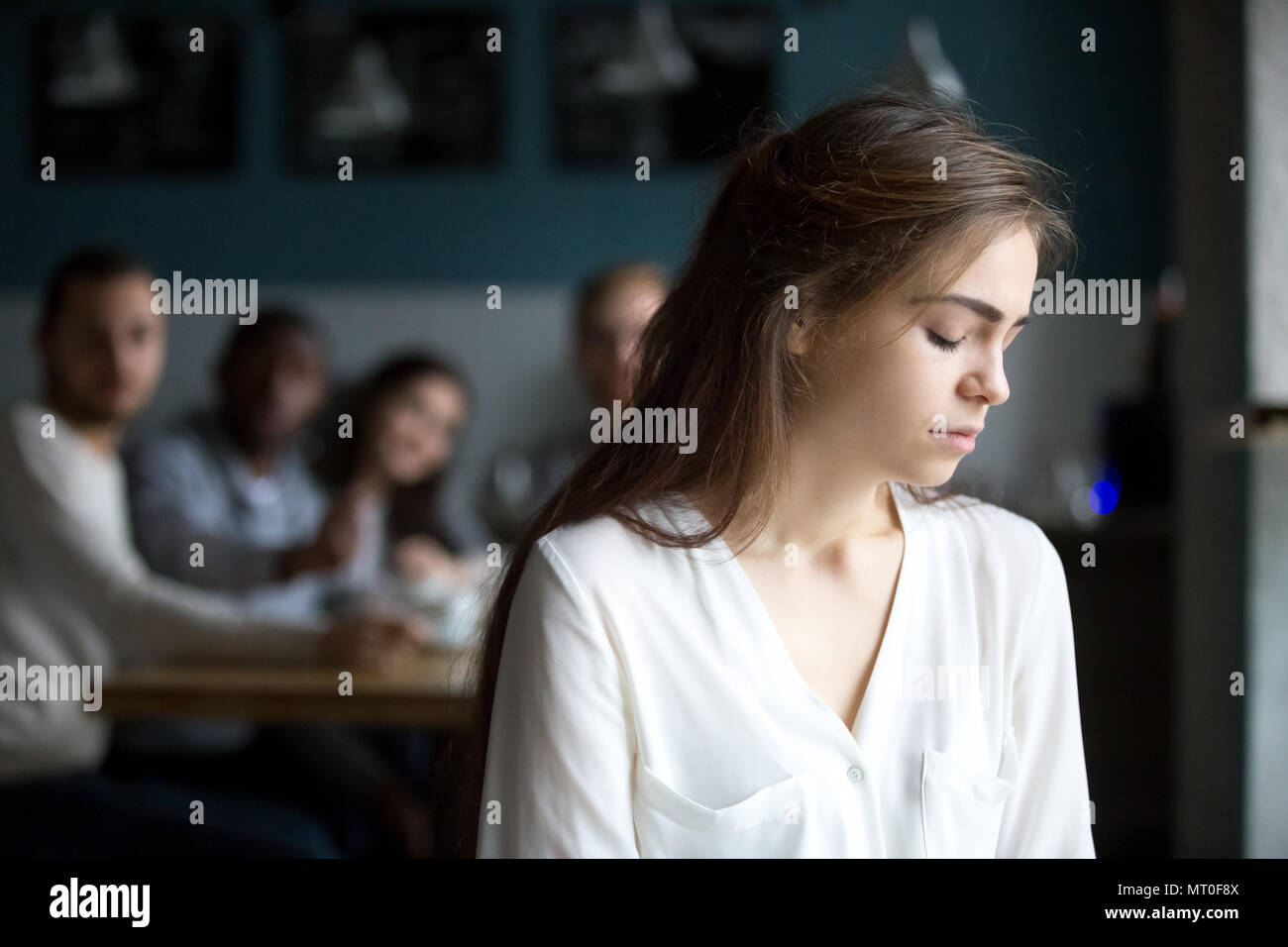 Triste giovane donna evitando gli amici che soffrono di spettegolare o bul Foto Stock