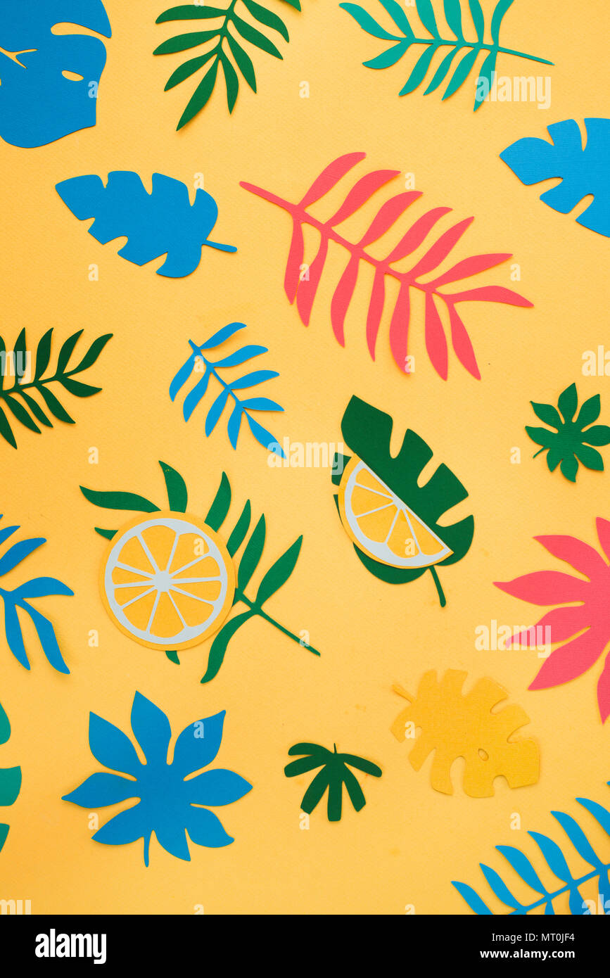 Tropical foglie e frutti pattern su un giallo brillante background. Estivo soleggiato appartamento colorato laici carta con ritagli. Foto Stock