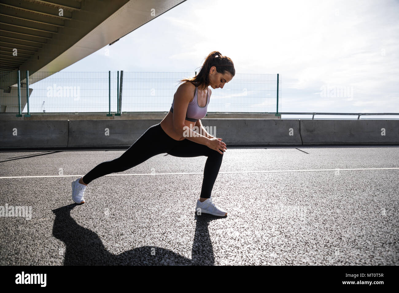 Colpo all'aperto del modello di fitness riscaldare gambe prima del training Foto Stock