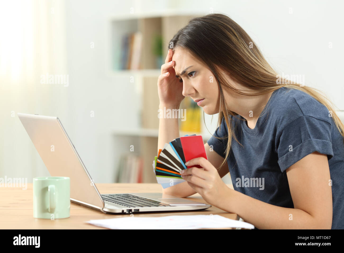 Vista laterale verticale di un preoccupato shopper in possesso di più carte di credito Verifica gli acquisti online Foto Stock