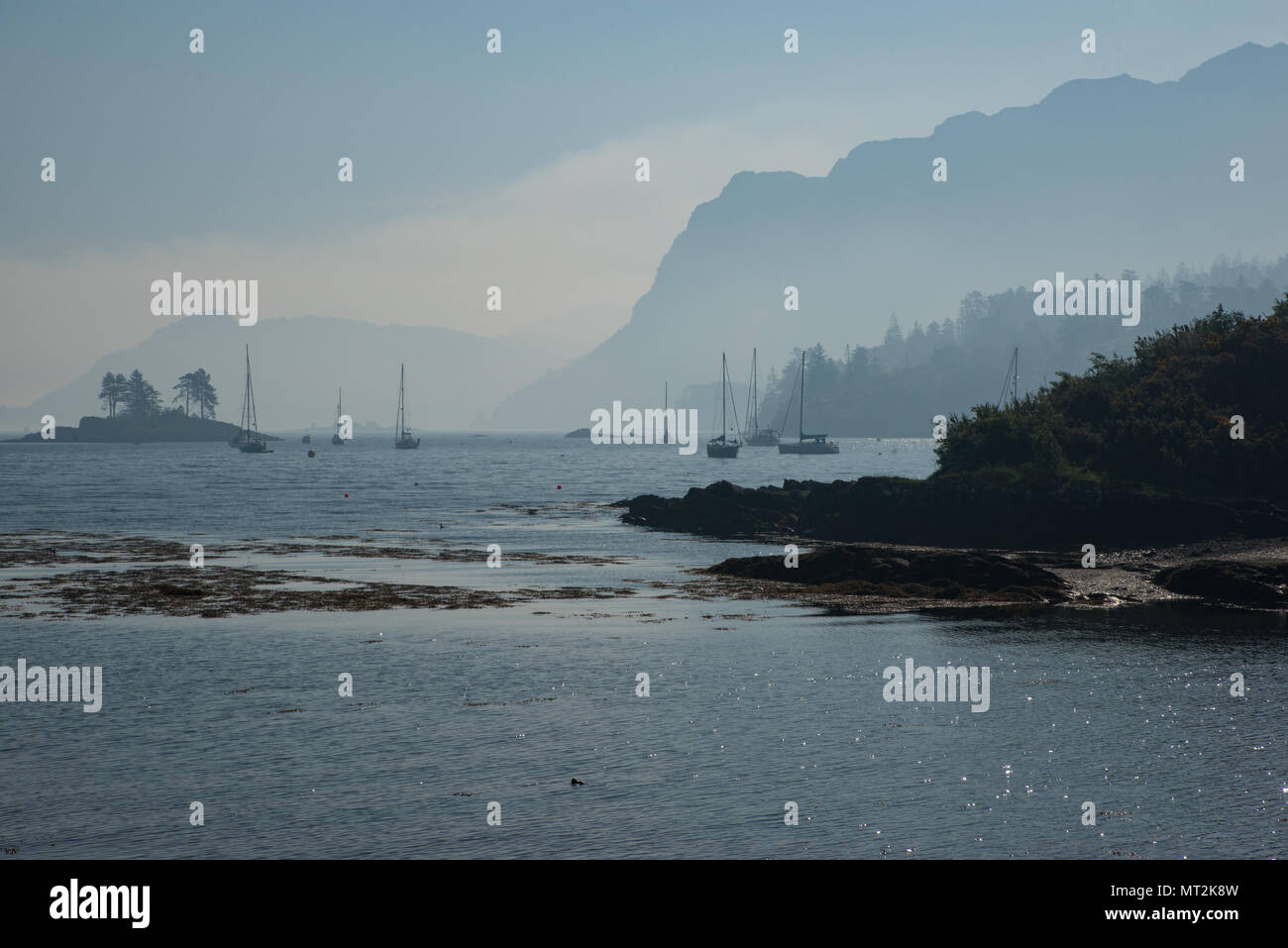 Gli incendi breakout nel West Highlands della Scozia causando una spessa smoky haze oltre Plockton Harbour al mattino. Foto Stock