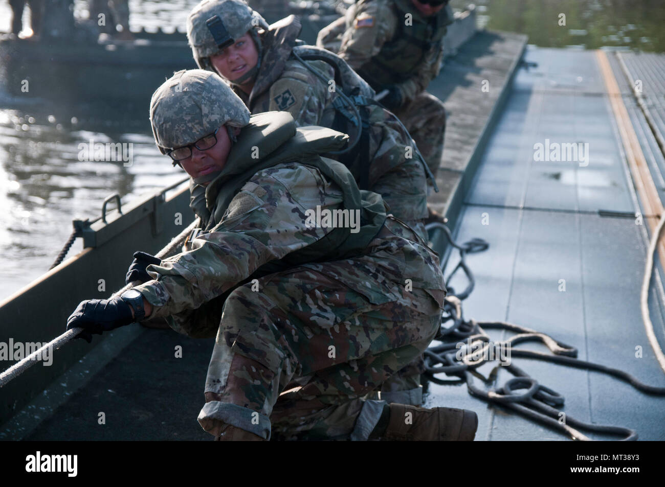 Attivi i soldati dell esercito dal 502nd Multi Role Bridge Co., tirare corde per allineare il ponte interno bay insieme le sezioni. Stati Uniti Esercito, attivo e soldati di riserva unirsi con Active e riserva componenti Marine per distribuire, costruire e assemblare un circa 320 metro galleggiante nastro migliorate ponte che attraversa il fiume Arkansas durante il fiume Assault 2017, a Fort Chaffee Centro di manovra, arca. Luglio 26, 2017. Fiume Assault 2017 è una di due settimane di combattimento prolungato esercizio di formazione detenuti luglio 15-28 concentrandosi sulle competenze tecniche di vari elementi di servizio, culminato con la costruzione di un galleggiante impr Foto Stock