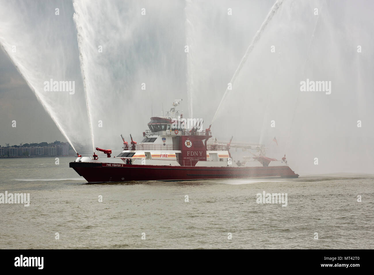 Il Fire Fighter II, un fireboat nella città di New York, spruzza acqua nel porto di New York. Foto Stock