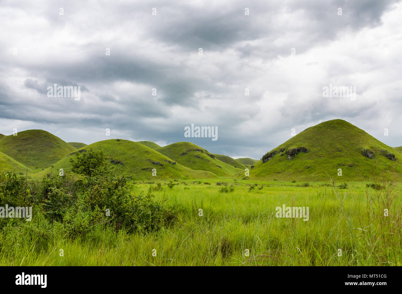 Colline e lussureggianti e verdi di erba e soffici nuvole bianche nella campagna della Repubblica del Congo, Africa centrale Foto Stock