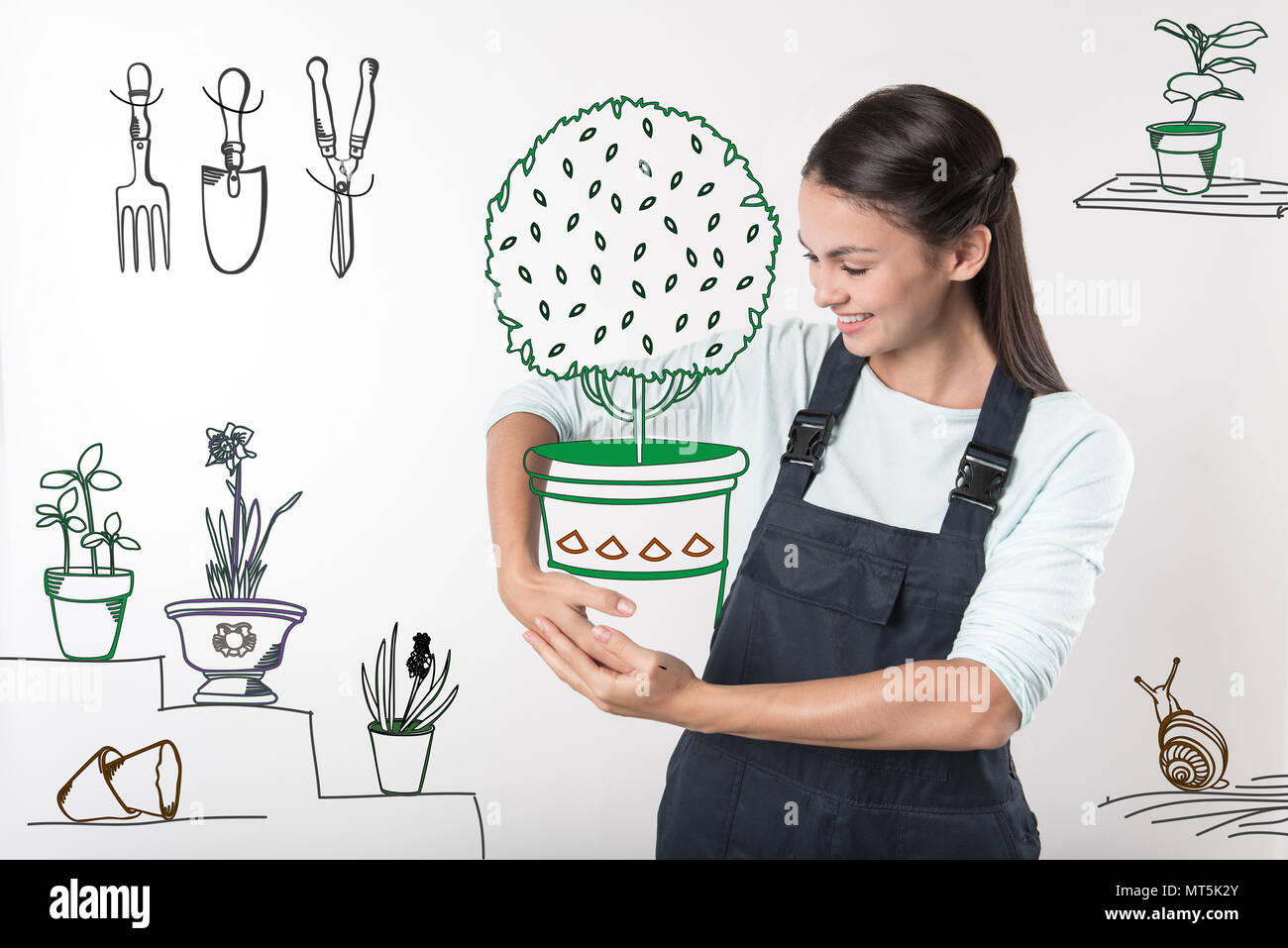 Tipo giardiniere sorridente mentre si tiene un grande vaso di fiori Foto Stock