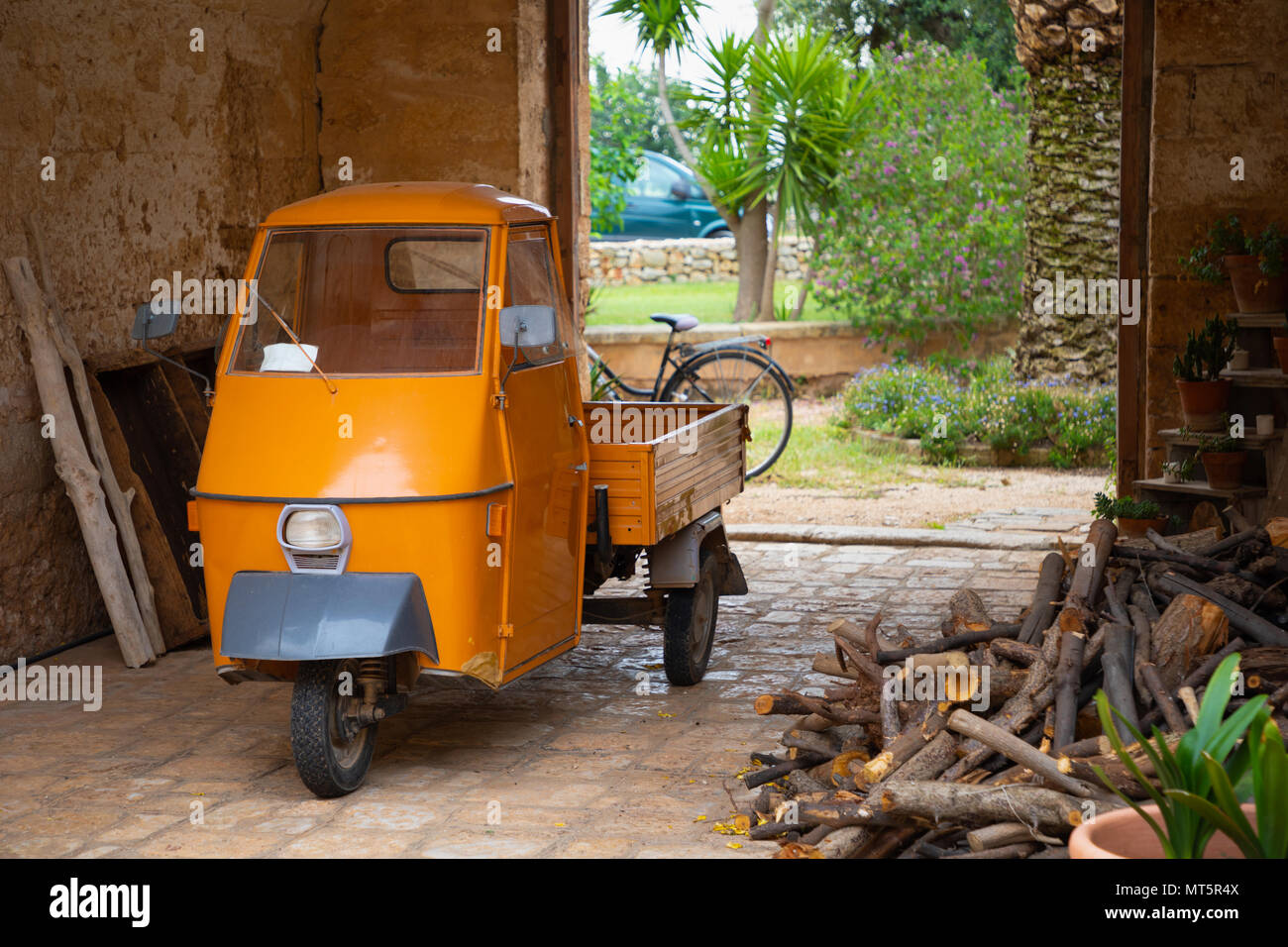 Arancione tre ruote vettura usata per il trasporto Foto Stock