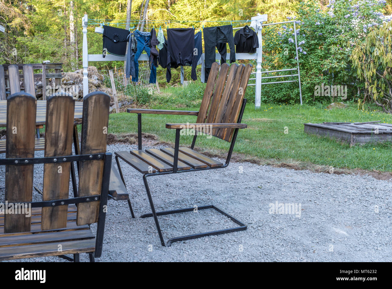 Sedie da giardino e vestiti su una linea di lavaggio in un giardino svedese Foto Stock