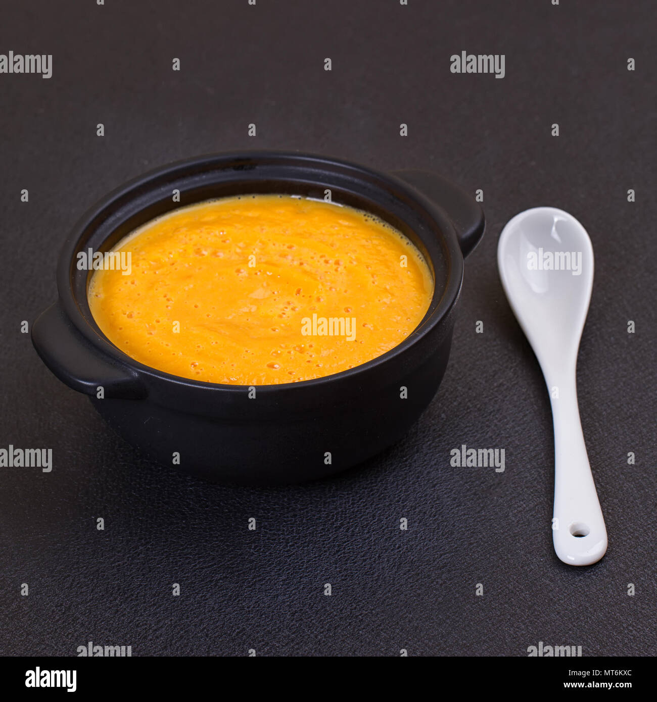 Zuppa di zucca in piccola zuppiera nero su ardesia vintage chalk board Foto Stock