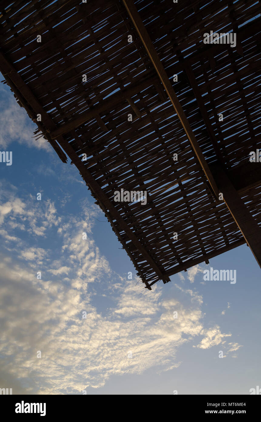 Silhouette di bamboo naturale tetto contro bel cielo azzurro con soffici nuvole a costa del Senegal, Africa Foto Stock