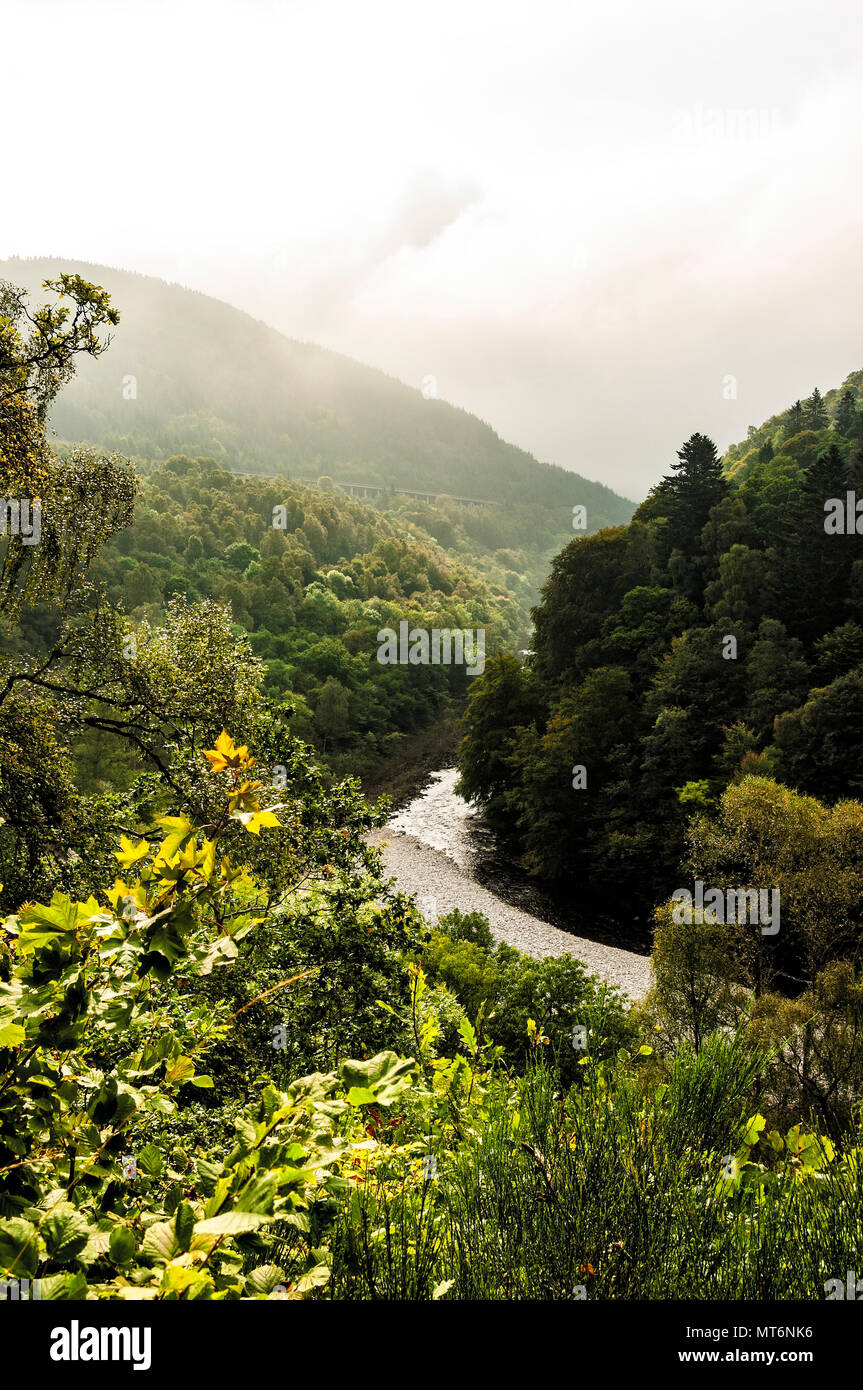 Luce del sole di mattina cade sul tranquillo Fiume Garry circondato da foreste mentre la nebbia avvolge Ben Vrackie e Tenandry Hill a passare di Killicrankie Foto Stock