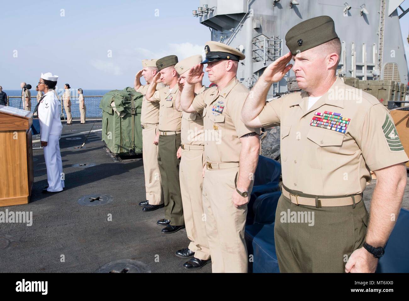 170916-N-UK248-016 U.S. 5TH FLOTTA AREA DI OPERAZIONI (sett. 16, 2017) La festa ufficiale rende saluta il ensign nazionale durante la presentazione di colori presso il Chief petty Officer (CPO) cerimonia di pinning a bordo del dock anfibio sbarco nave USS Pearl Harbor (LSD 52). Pearl Harbor è parte dell'America anfibio gruppo pronto (ARG) e, con l'avviato xv Marine Expeditionary Unit (MEU), è distribuito come supporto di le operazioni di sicurezza marittima e di teatro la cooperazione in materia di sicurezza gli sforzi negli Stati Uniti Quinta Flotta area di operazioni. (U.S. Foto di Marina di Massa Specialista comunicazione 2° Cla Foto Stock