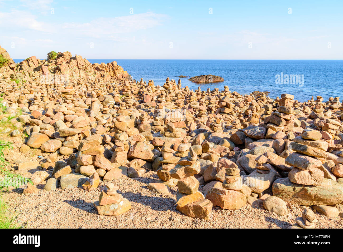 Un sacco di pilastri in pietra o roccia di bilanciamento messo nel paesaggio costiero passando per i turisti. Hovs Hallar in Bjare riserva naturale in Svezia. Foto Stock