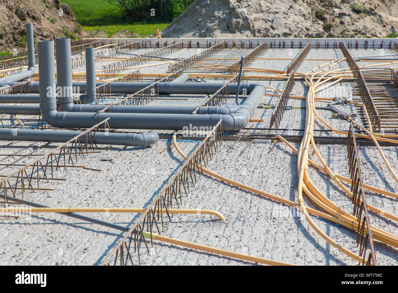 Pavimento in calcestruzzo dell'edificio con tubi sul sito in costruzione Foto Stock