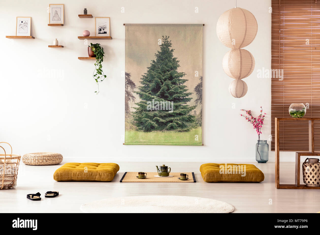Giapponese sala da pranzo interno con un albero di poster, lampada, cuscini e tatami con pentola e tazze sul pavimento Foto Stock