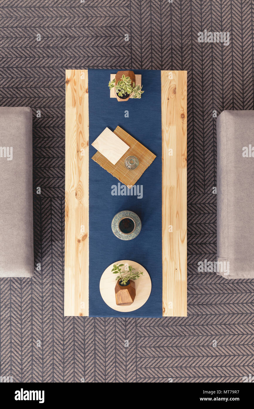 Elevato angolo di una tavola con un impianto, documenti Cup e la piastra su un tappeto grigio Foto Stock