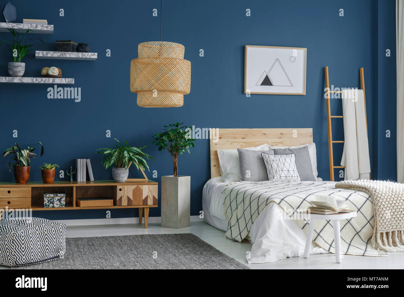Vista laterale di una camera da letto blu interno con una moderna lampada,  letto doppio, piante e cabinet Foto stock - Alamy