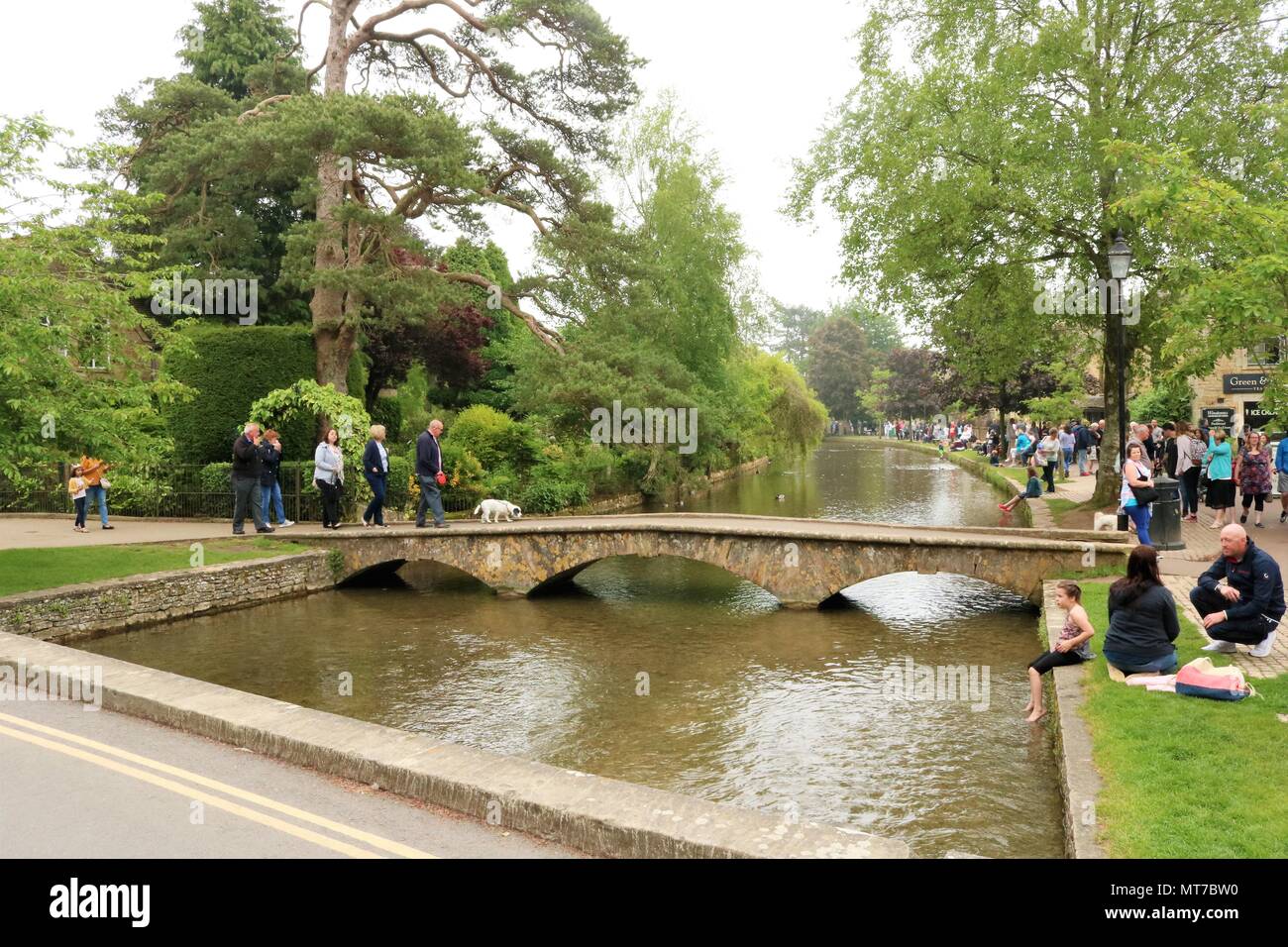 Le persone che si godono le vacanze di maggio a Bourton sull'acqua, Gloucestershire, Regno Unito entro il Cotswolds Area di straordinaria bellezza naturale Foto Stock