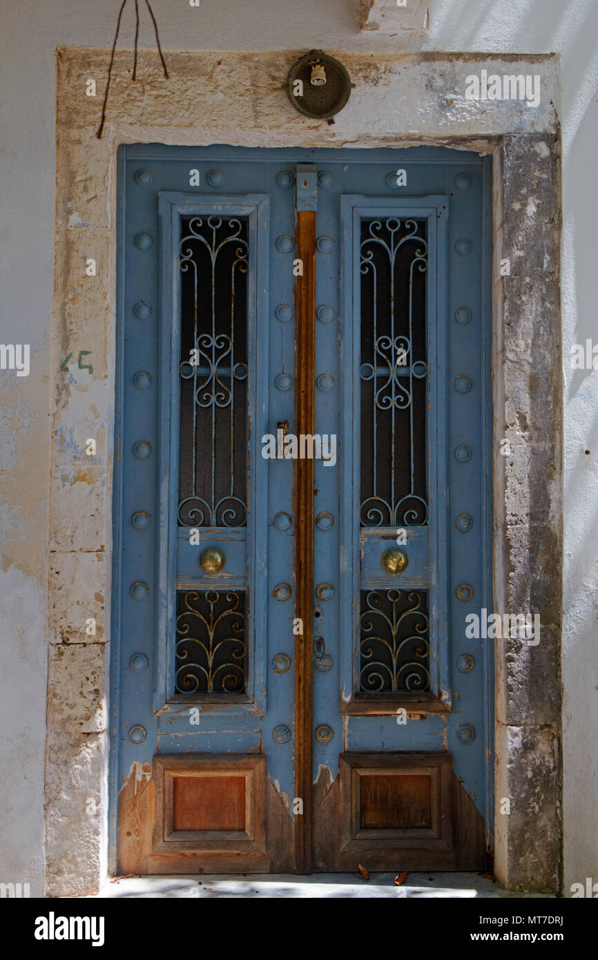 Indossati in legno di colore blu con porta di vetro e ferro battuto in un vecchio edificio in Fiskardo sull'isola greca di Cefalonia Foto Stock