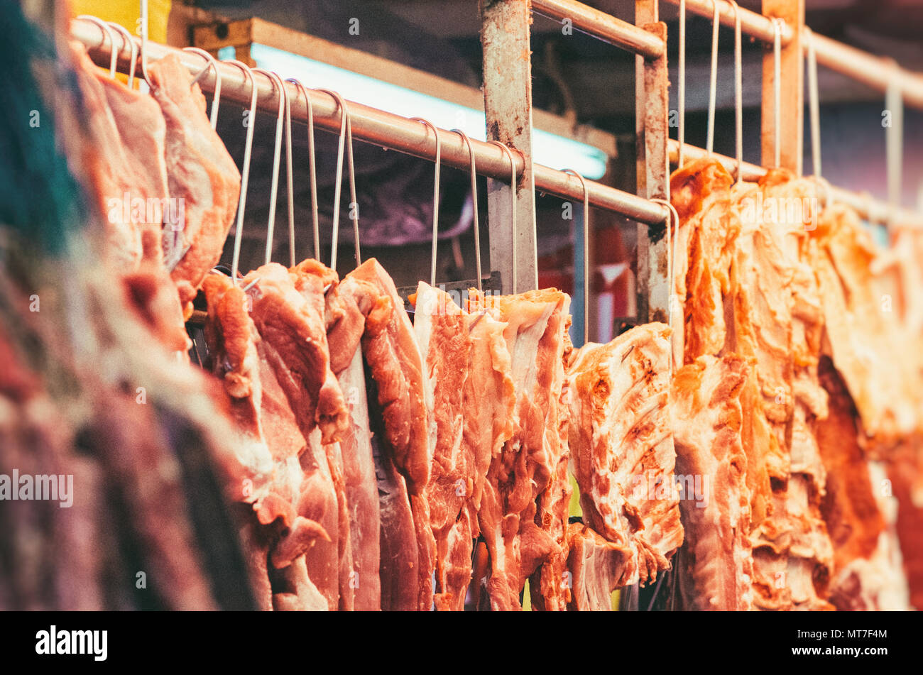 Macellaio di carne di maiale di vendita nel mercato di Hong Kong. Foto Stock