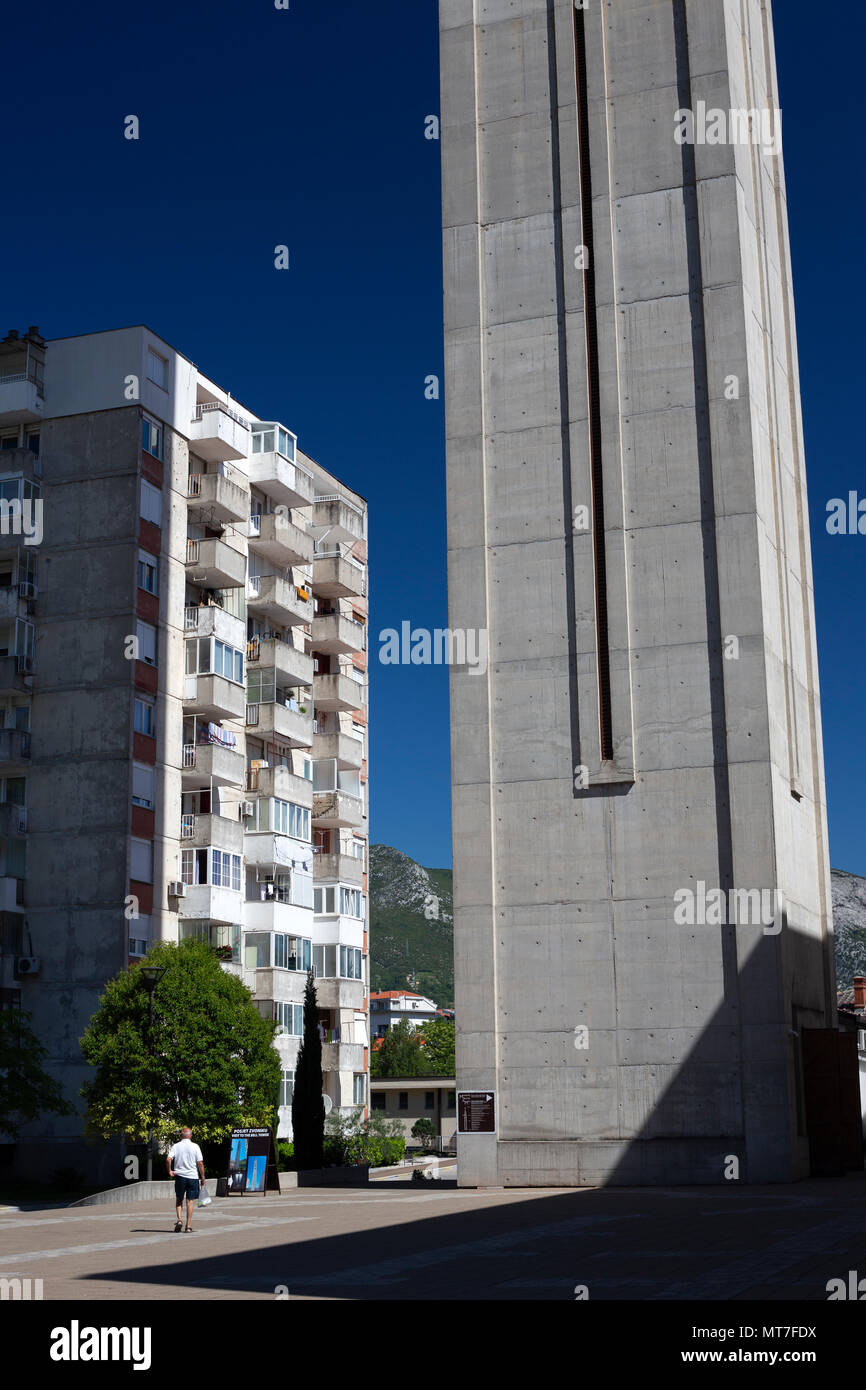 A Mostar (Bosnia Erzegovina), un blocco di appartamenti dominato dal nuovo campanile di San Pietro e Paolo chiesa francescana (350.96 piedi alto). Foto Stock
