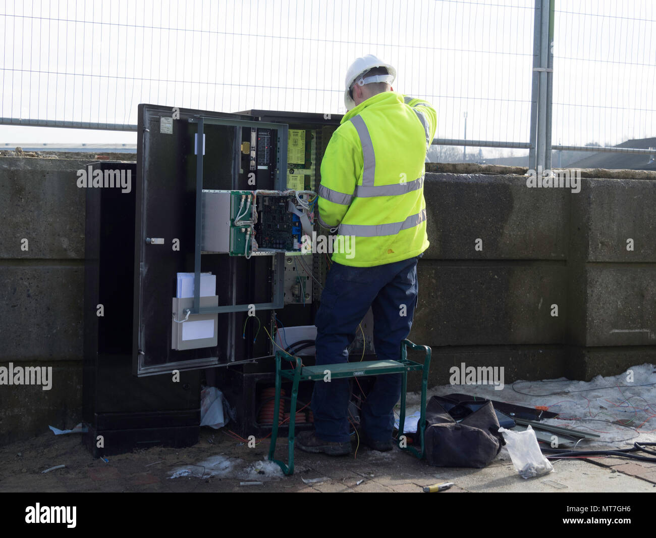 Il tecnico elettricista lavorando su una strada interruttore elettrico di bordo per un nuovo impianto di illuminazione Foto Stock