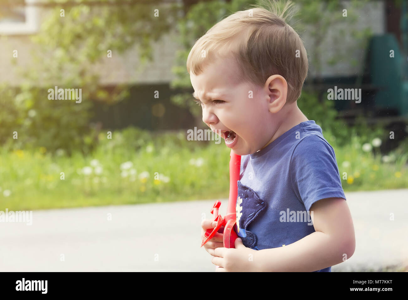 Il bambino piange di risentimento, Sob sobbingly che copre il viso con le mani Foto Stock