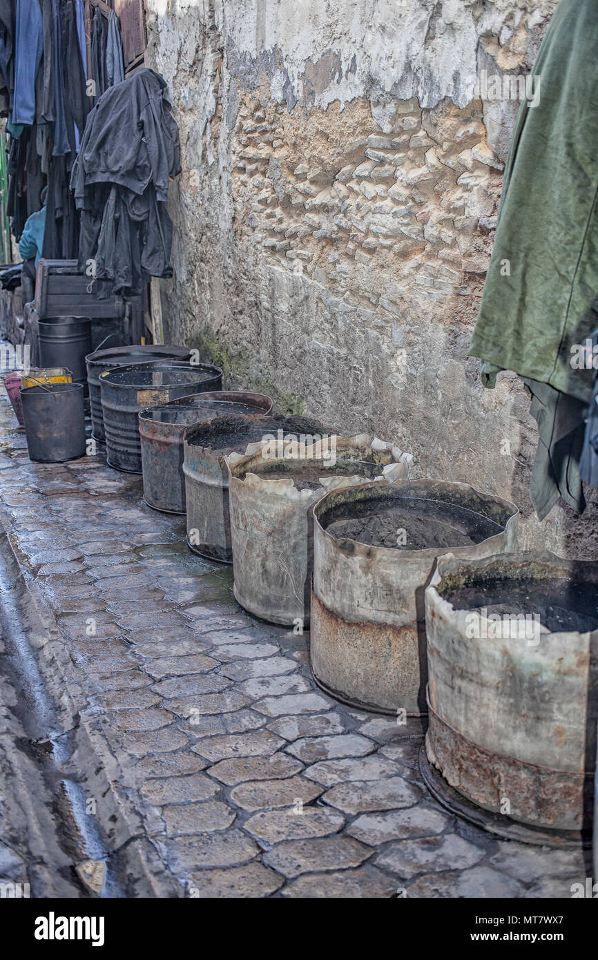 Secchielli in plastica con acqua su una strada nella zona conceria di Fez, Marocco Foto Stock