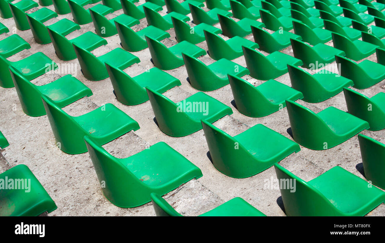 Molti di plastica verde posti in fila in un stadio vuoto. Foto Stock