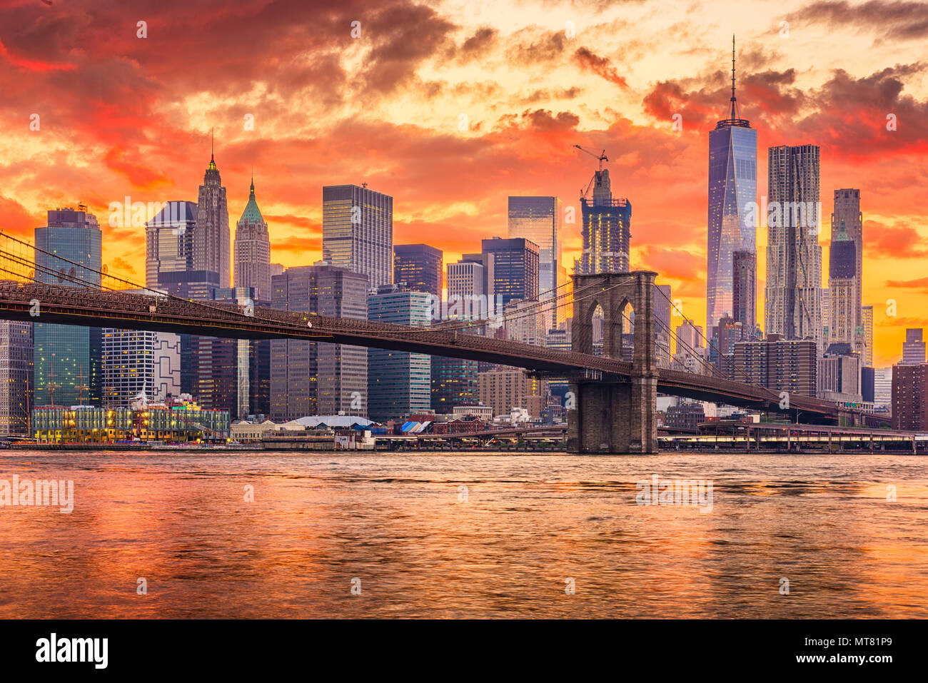 New York, New York, Stati Uniti d'America skyline di Manhattan sull'East River con ponte di Brooklyn dopo il tramonto. Foto Stock