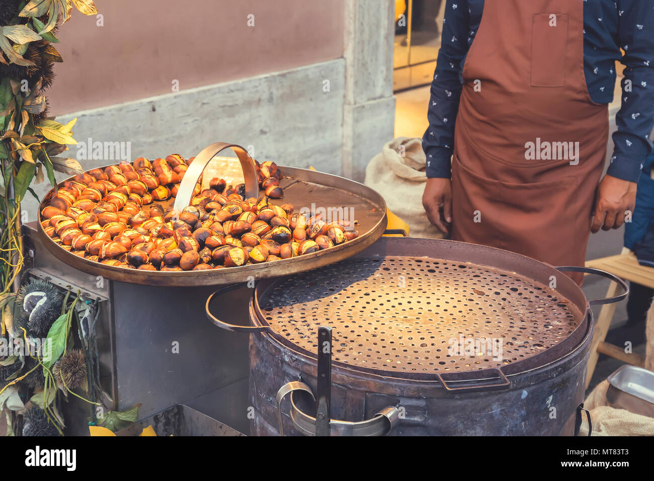L'uomo vendere tostatura di castagne e marroni a strade di Roma, Italia. In stile vintage. Foto Stock