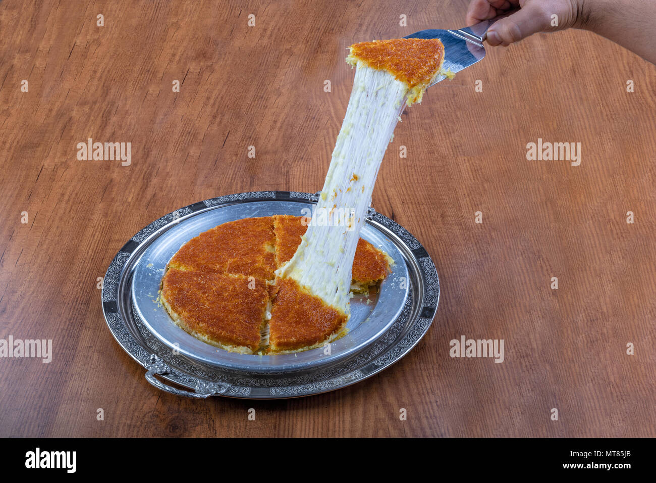 Dolce turco kunefe, kunafa, kadayif con polvere di pistacchi e formaggio hot mangiato un dolce Foto Stock
