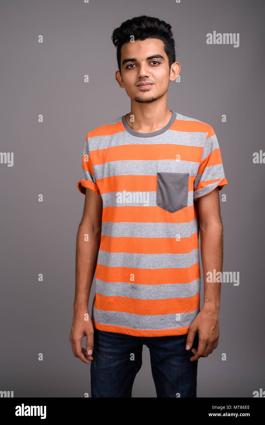 Giovani indiani uomo contro uno sfondo grigio Foto Stock