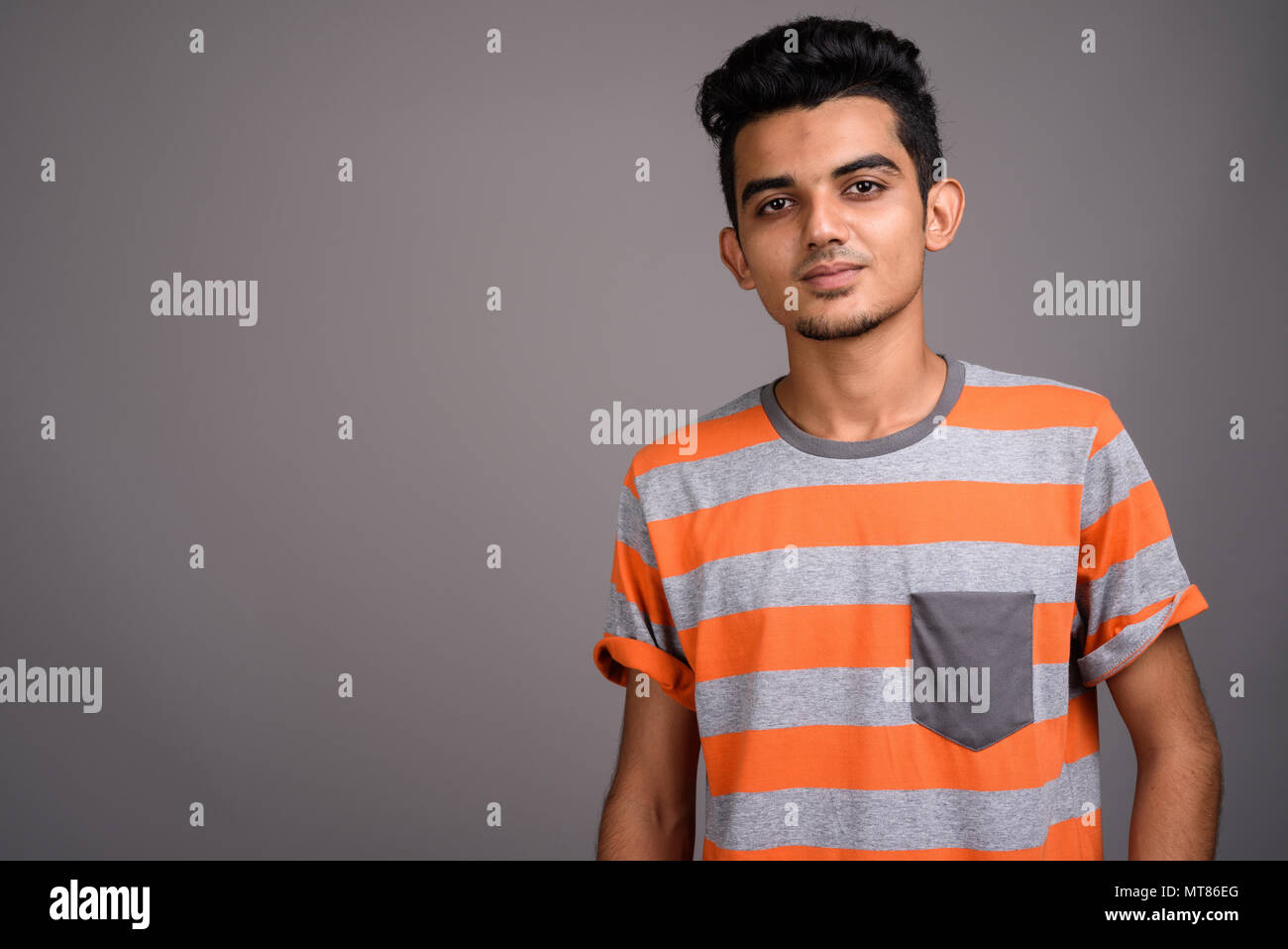 Giovani indiani uomo contro uno sfondo grigio Foto Stock