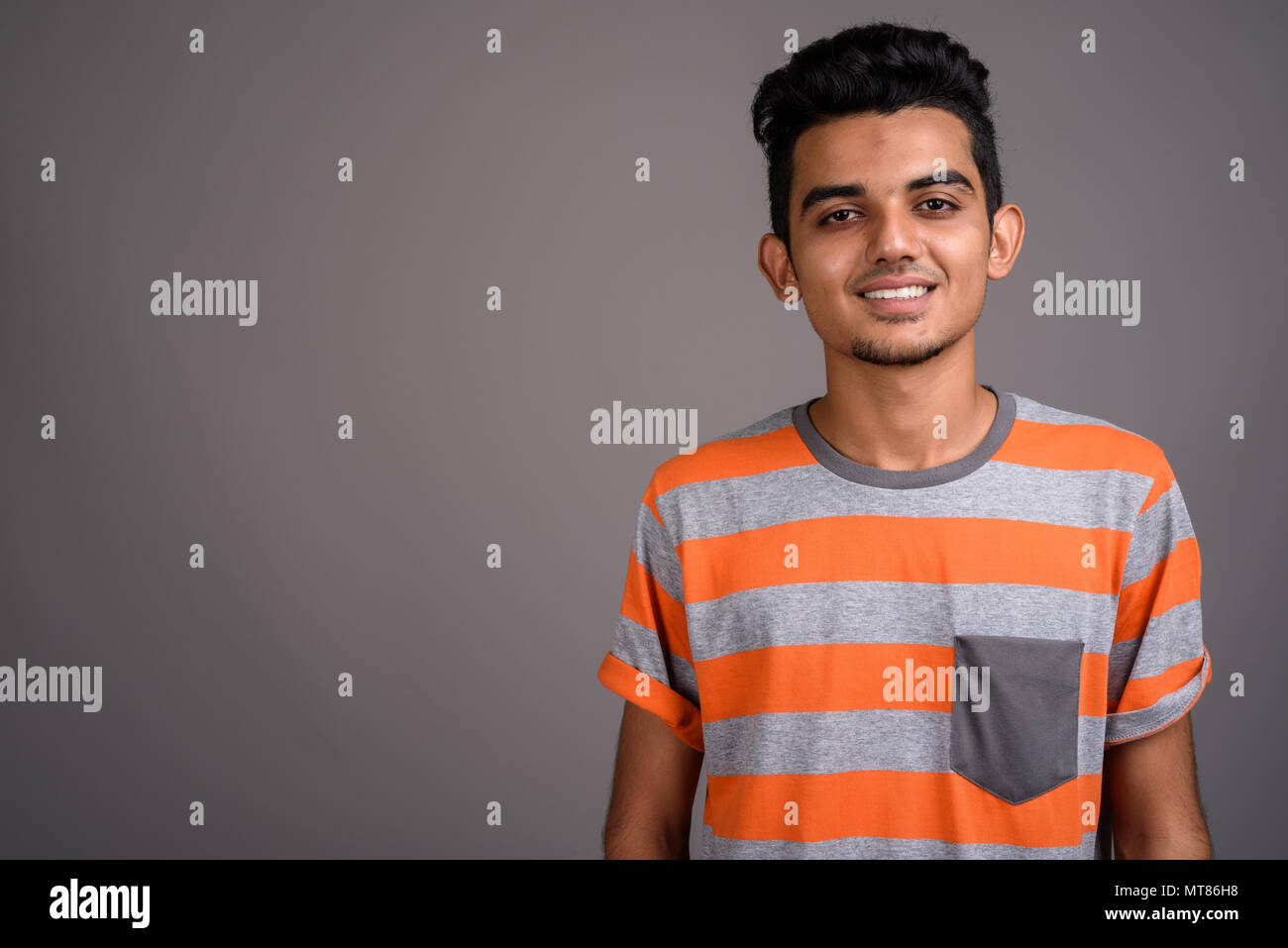 Giovani indiani uomo contro uno sfondo grigio Foto Stock