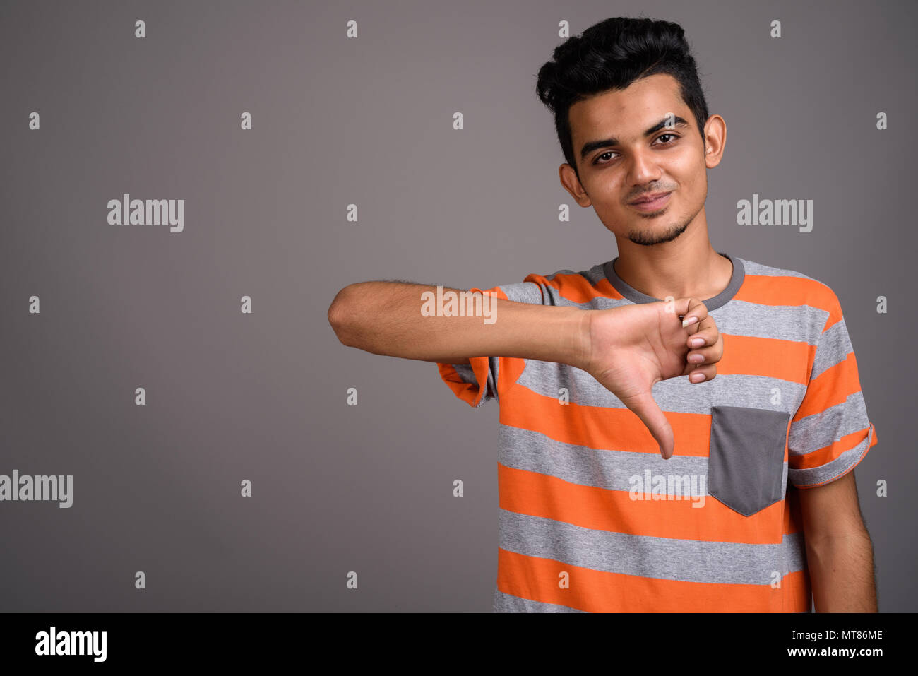 Giovani indiani uomo contro uno sfondo grigio Foto Stock