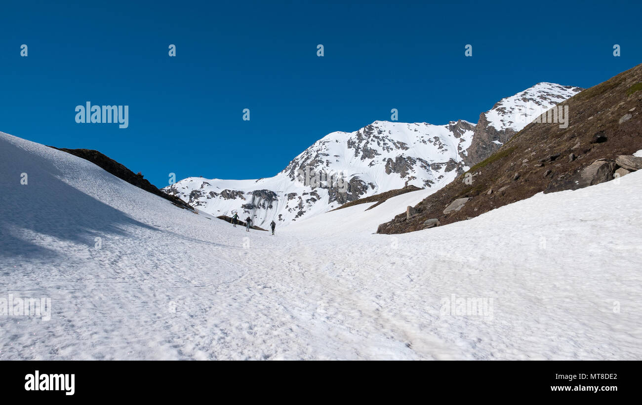 Alpinista escursionismo sci alpinismo sul pendio nevoso verso il vertice della montagna. Concetto di conquista delle avversità e raggiungere l'obiettivo. Foto Stock