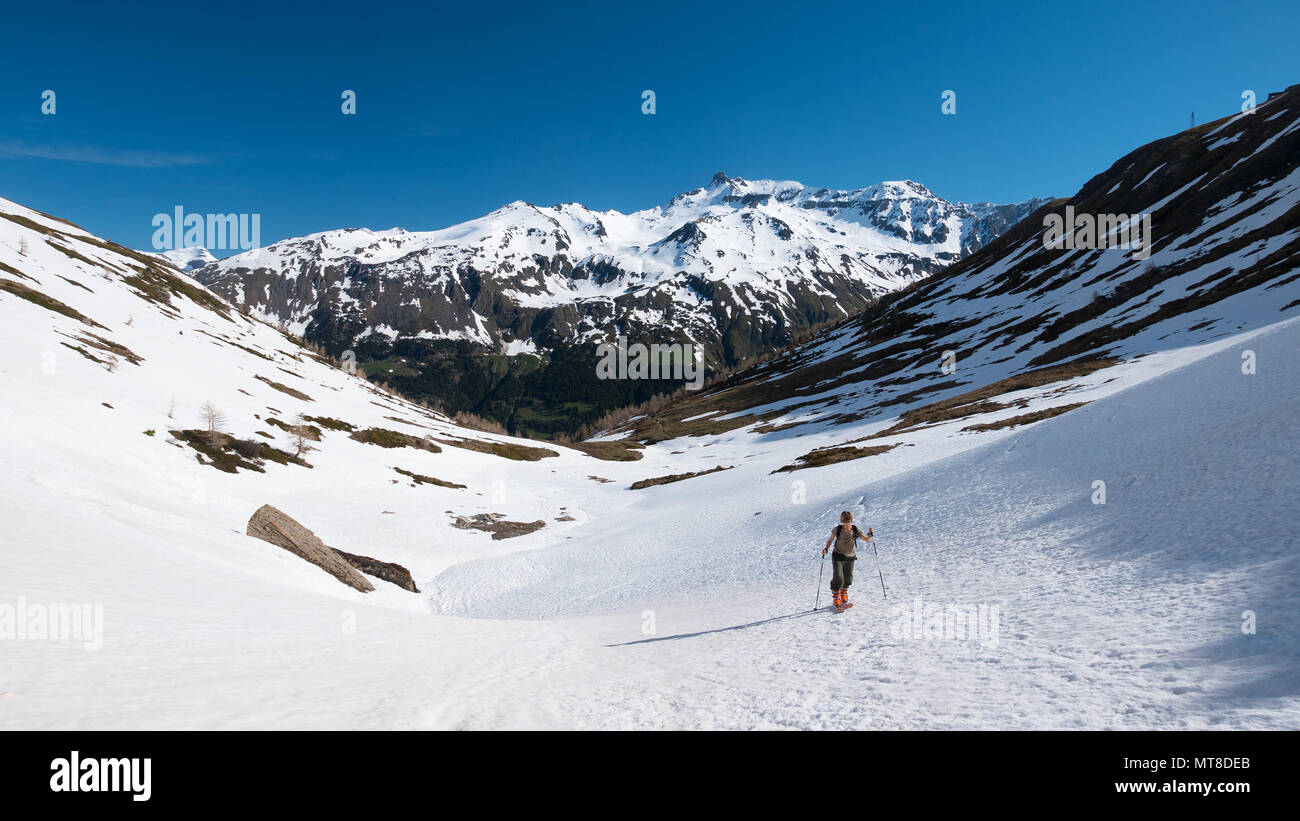 Alpinista escursionismo sci alpinismo sul pendio nevoso verso il vertice della montagna. Concetto di conquista delle avversità e raggiungere l'obiettivo. Foto Stock