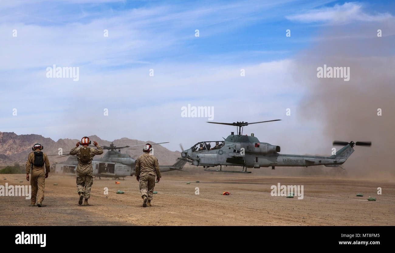 Ordnance Marines si muovono verso un AH-1Z Viper come terre durante le operazioni che sono una parte del supporto di assalto di formazione (AST) 1 a sostegno delle armi semestrale e tattiche corso istruttori (WTI) 2-17, al cioccolato Mountain Aerial Gunnery gamma, California, 17 aprile. Della durata di sette settimane, WTI è una evoluzione di formazione ospitati da MAWTS-1 che fornisce avanzate standardizzati e tattica di formazione e certificazione di istruttore d'unità qualifiche per il supporto di aviazione marino formazione e preparazione. Foto Stock